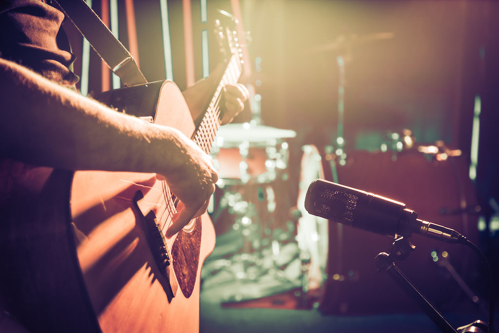 Closeup of guitar in front of a microphone at live concert